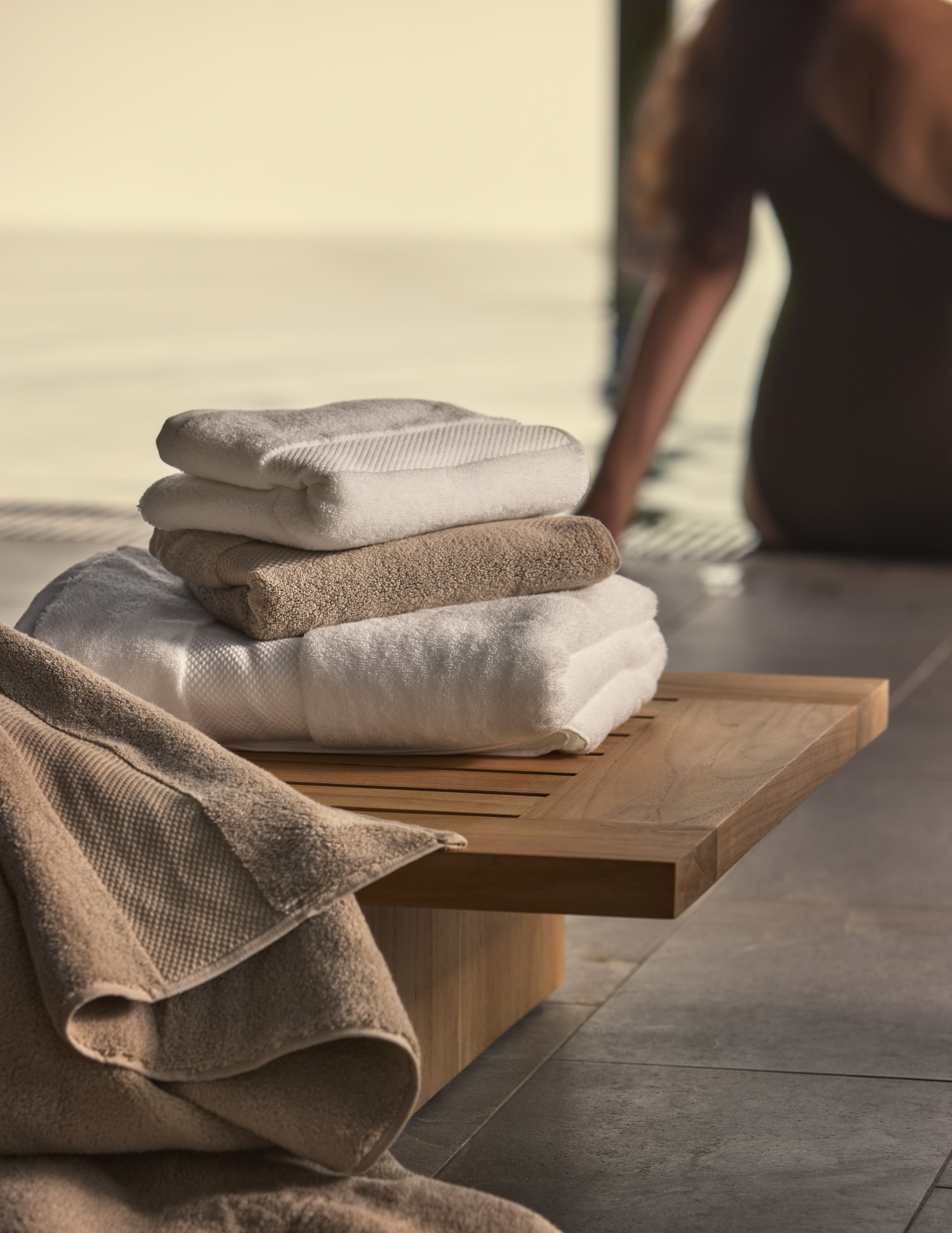 På en bänk vid ett spa ligger en hög med handdukar i olika färger