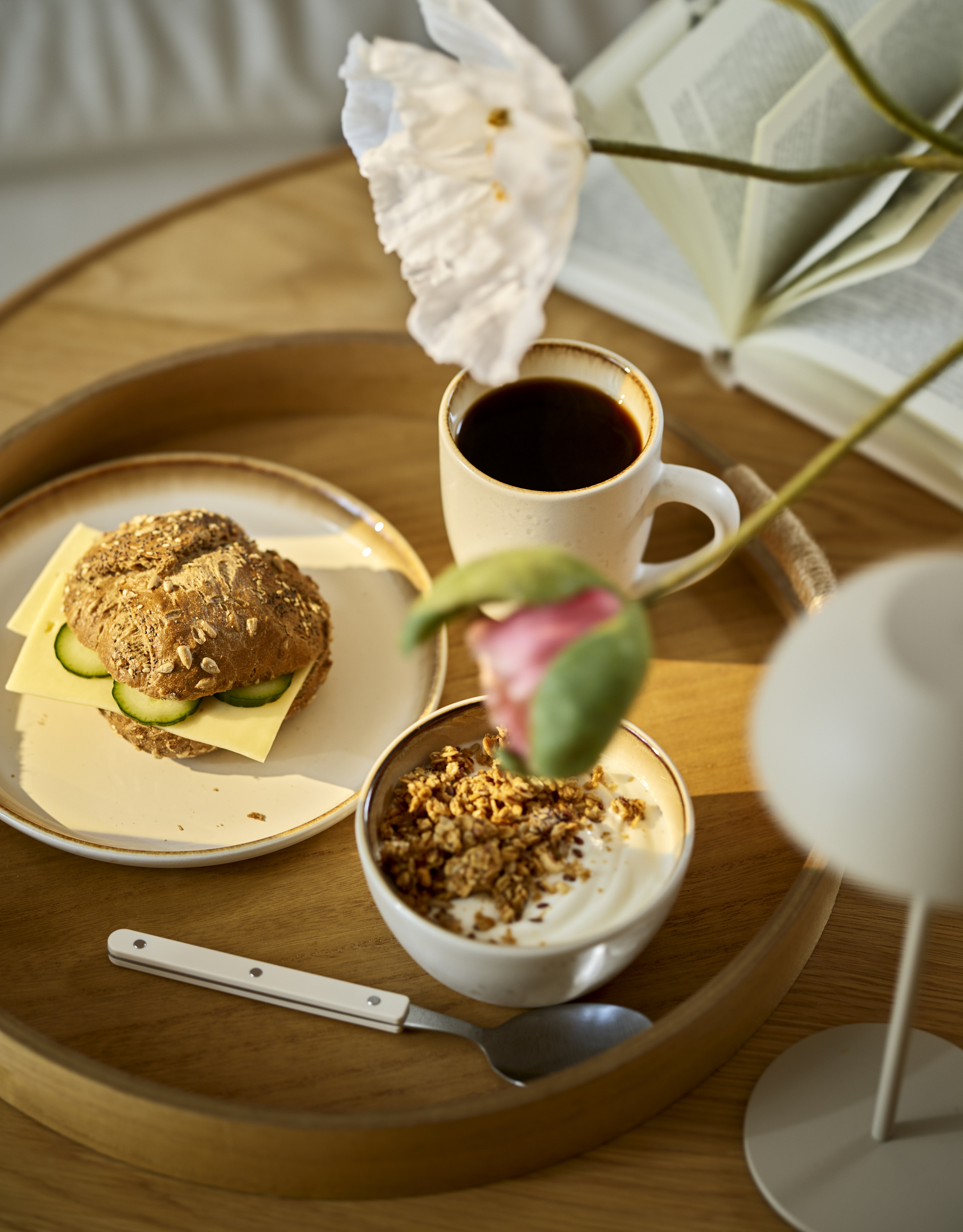 På ett runt soffbord står en bricka med porslin där frukost är uppdukat