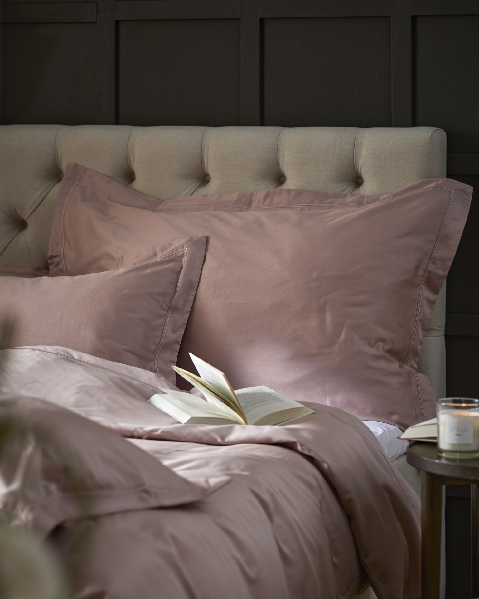 En beige kontinentalsäng bäddad med rosa påslakanset
