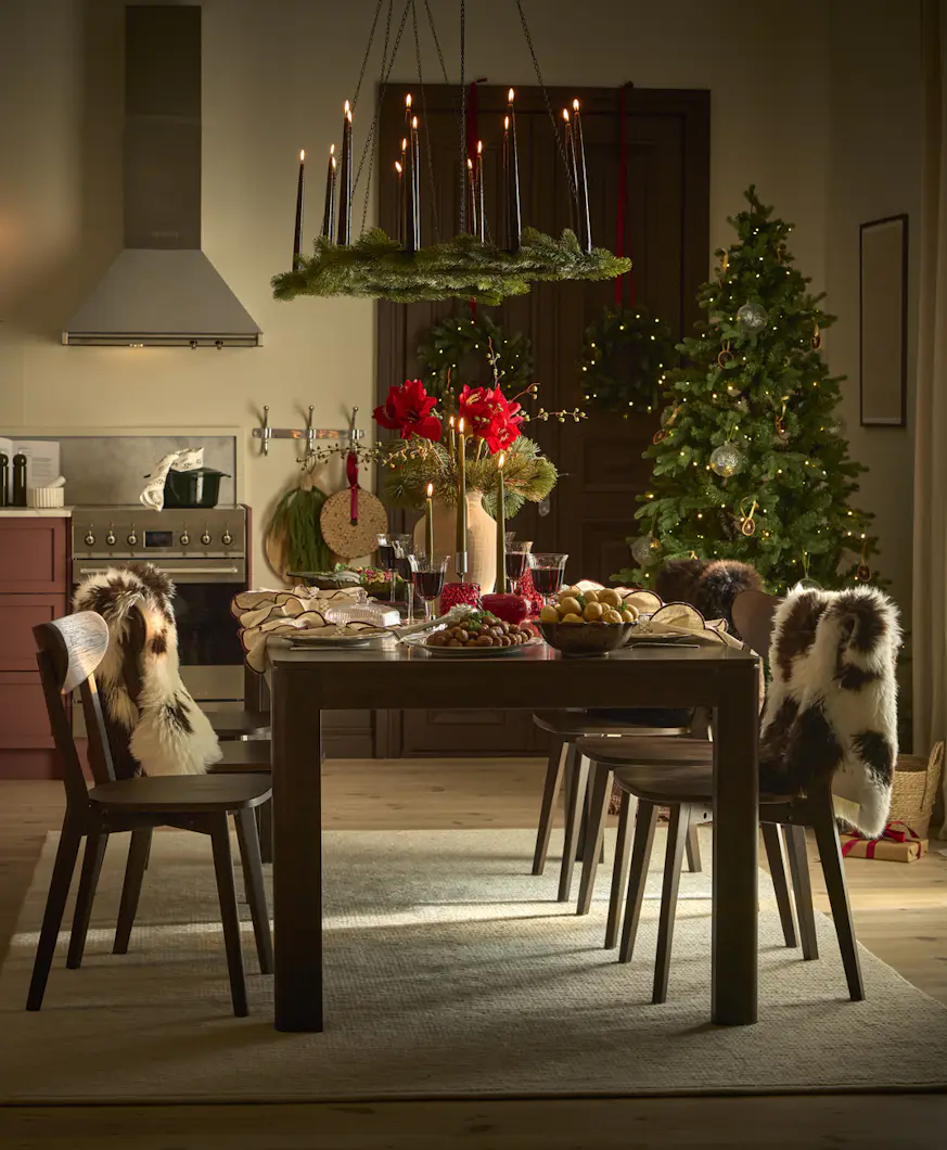 Julpyntad köksmiljö med ett mörkbrunt rektangulärt matbord och sex mörkbruna stolar.