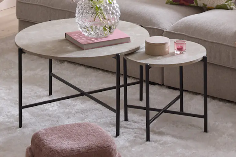 Grå soffa och grått satsbord i två delar står i ett rosa vardagsrum.