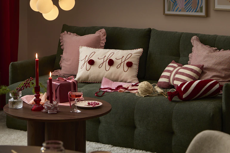 en grön bäddsoffa i ett julpyntat hem