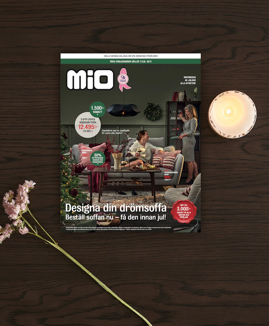 ett kampanjblad liggandes på ett bord med ett ljus och en blomma bredvid