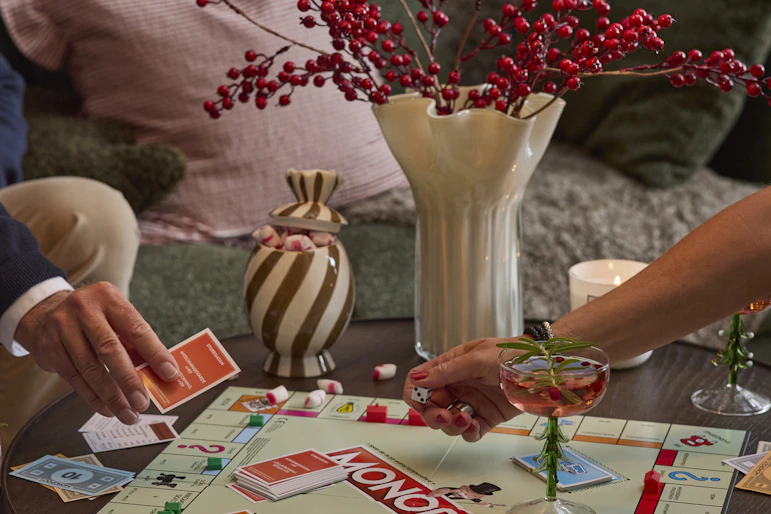 En man och en kvinna spelar Monopol på ett soffbord