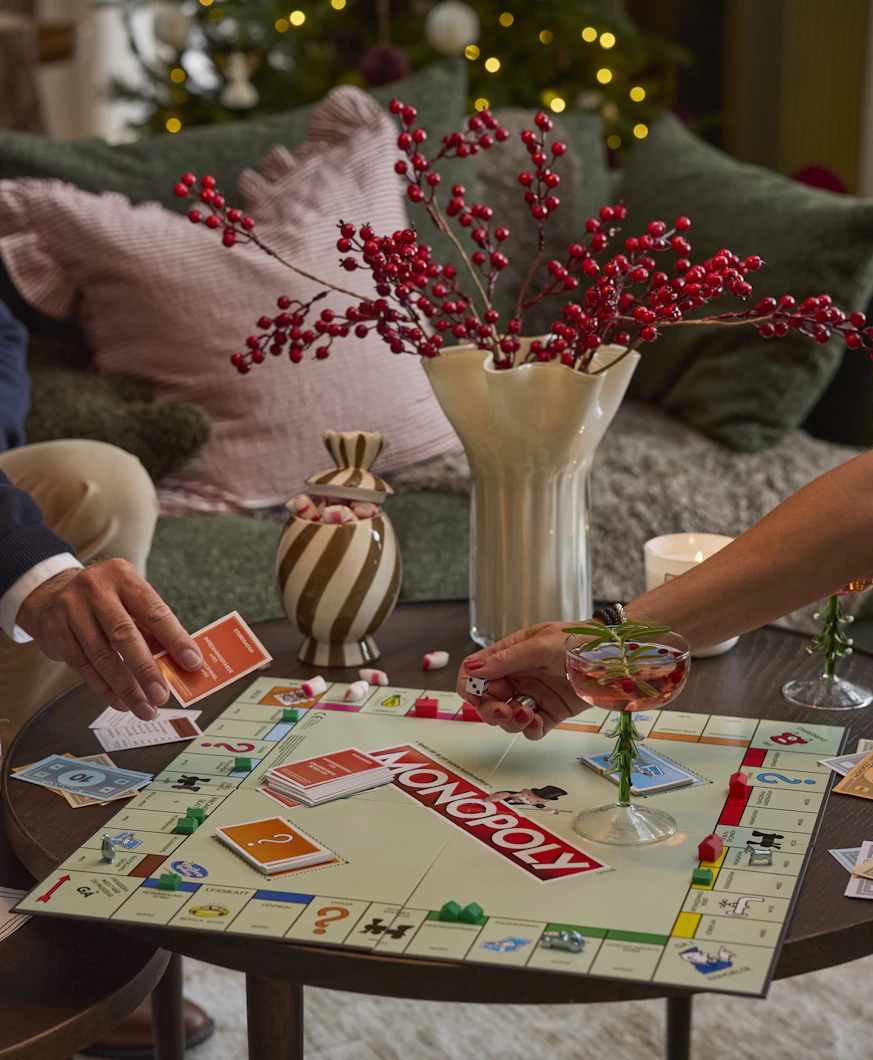 En man och en kvinna spelar Monopol på ett soffbord