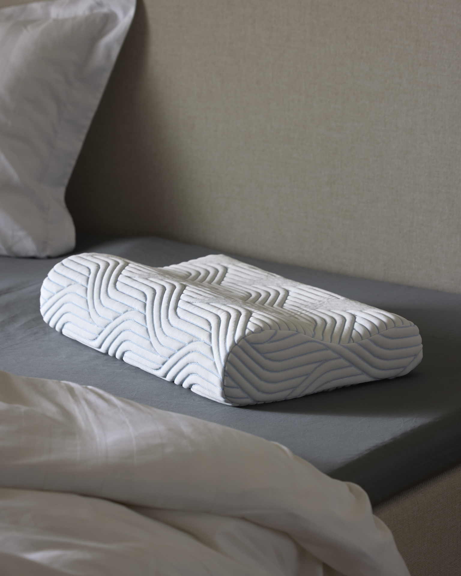 en vit funktionskudde på en säng