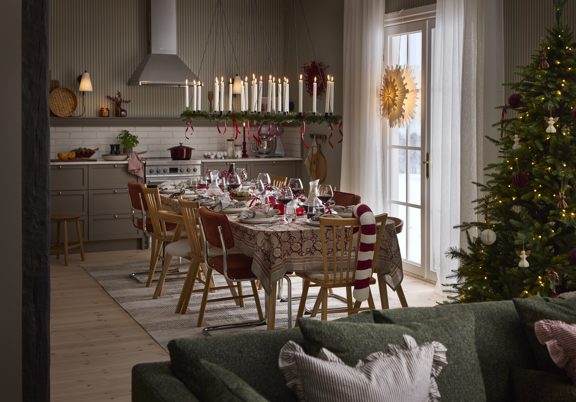 ett kök med ett stort dukat bord i mitten med olika stolar runt