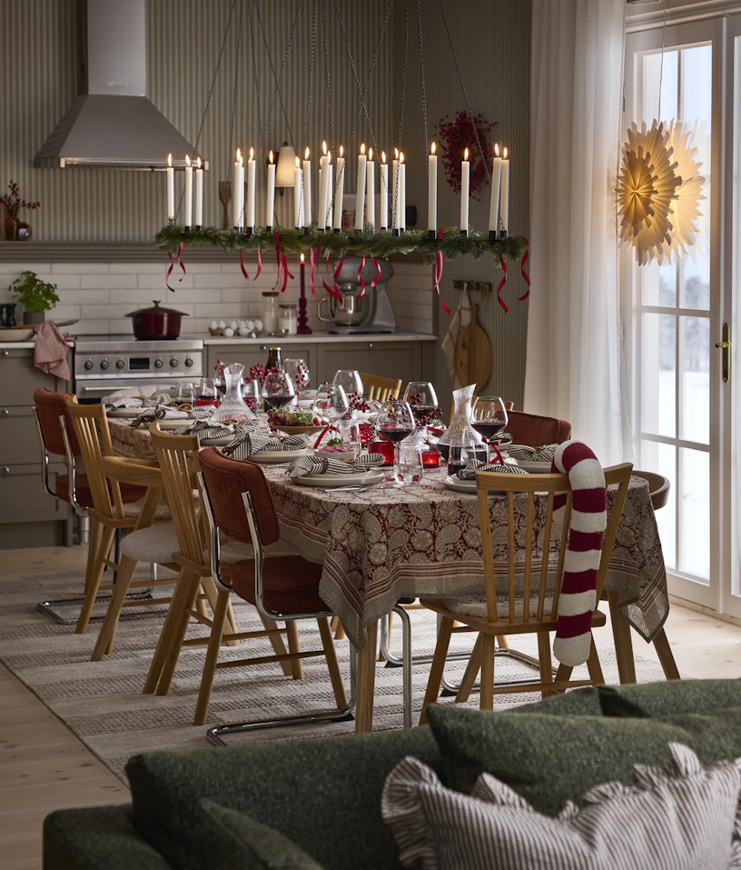 ett kök med ett stort dukat bord i mitten med olika stolar runt