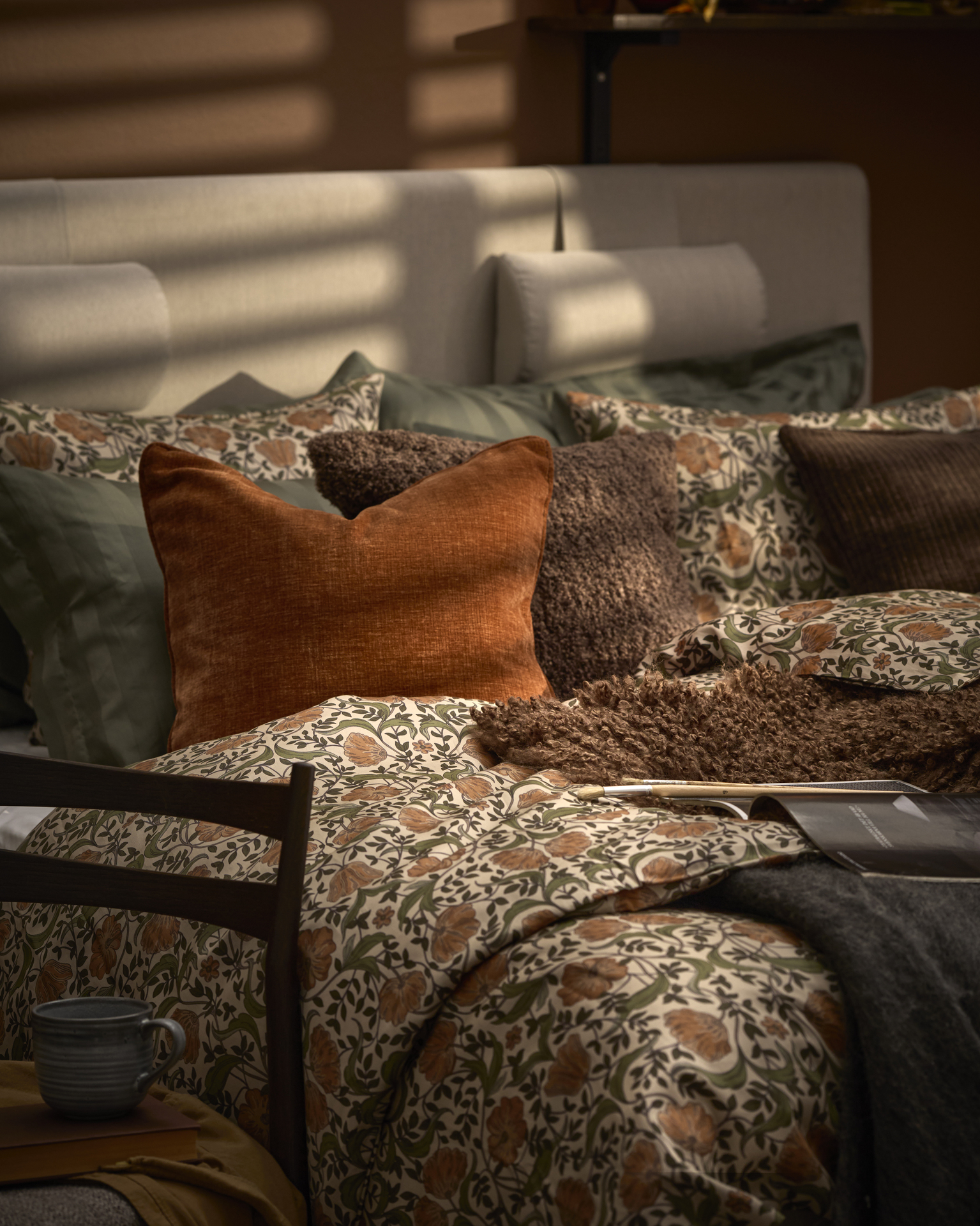 en säng bäddad med sängkläder i brunt mönster