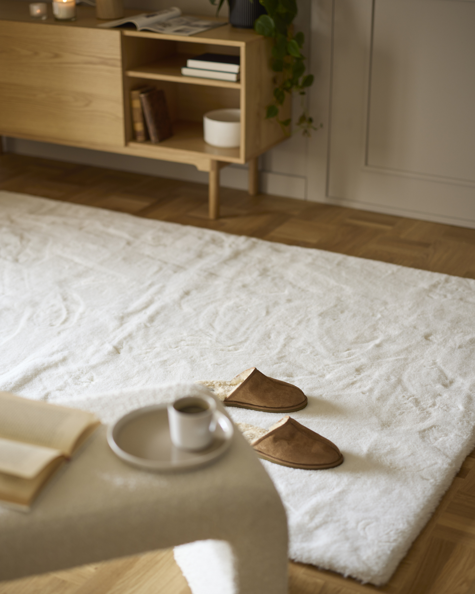 ett par tofflor ståendes på en vit lurvig matta