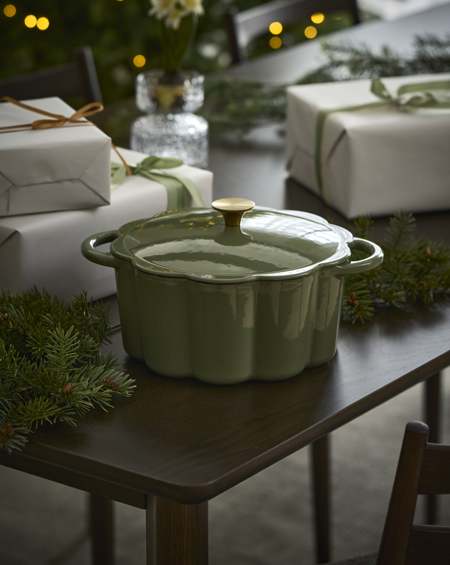 en grön gjutjärnsgryta på ett bord framför paket