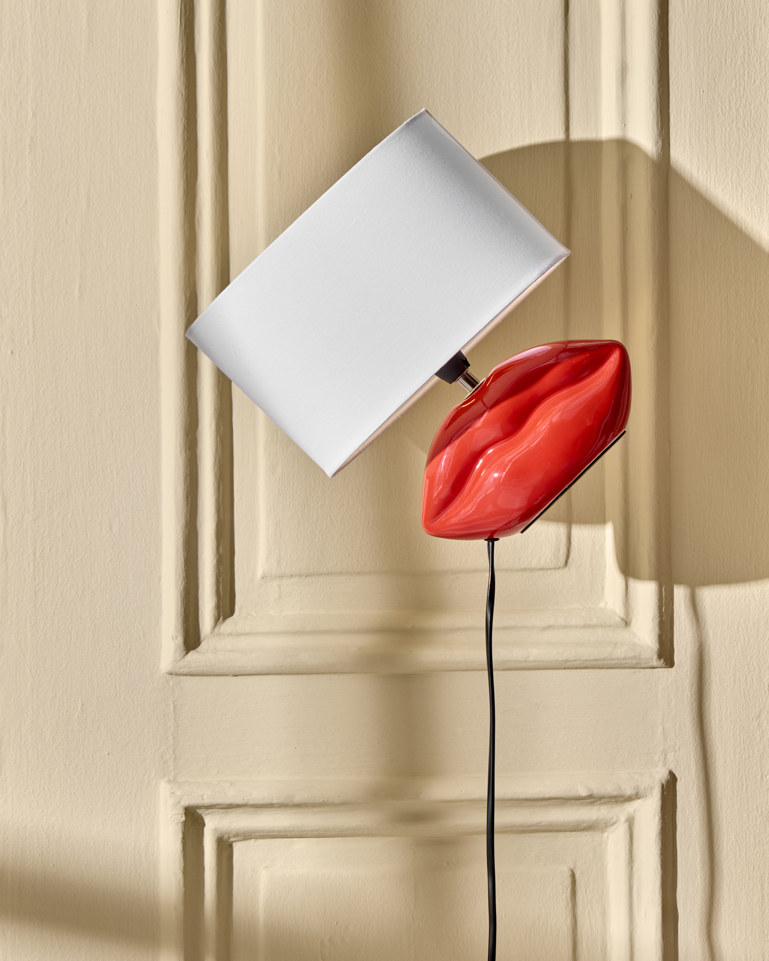 en lampa formad som en mun med en vit lampskärm