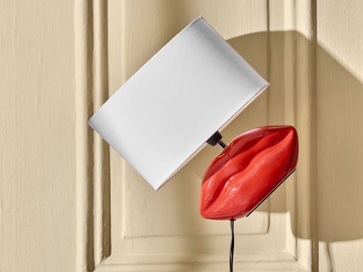 en lampa formad som en mun med en vit lampskärm