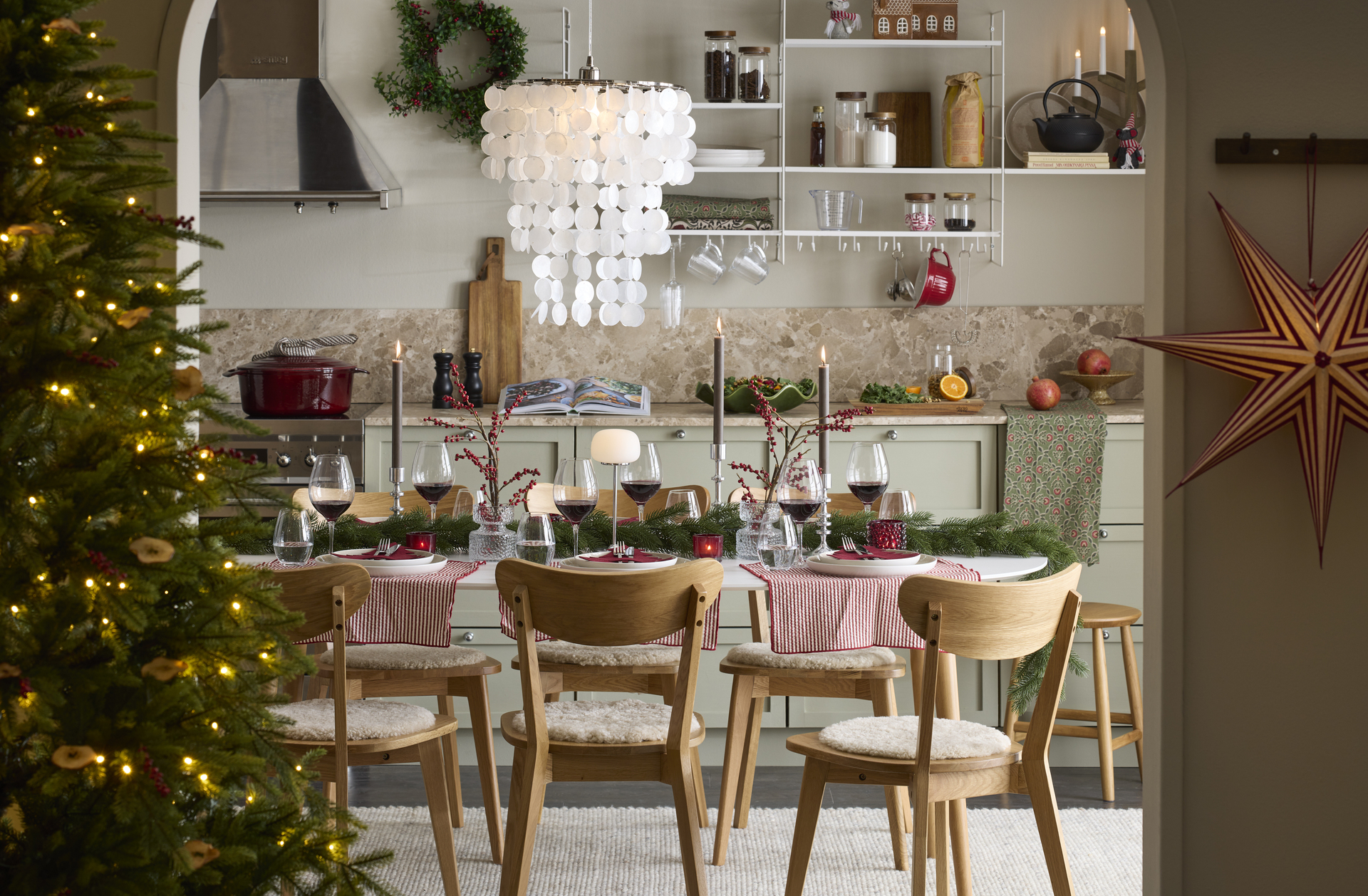 ett kök med julpynt och ett stort matbord med stolar