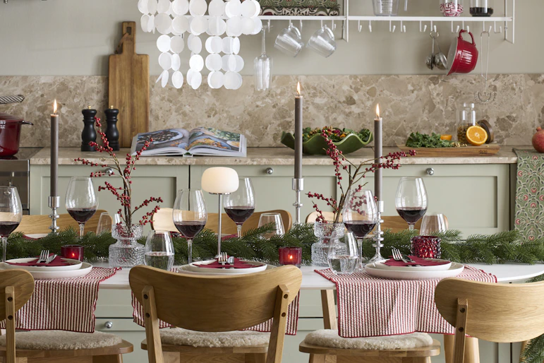 ett kök med julpynt och ett stort matbord med stolar