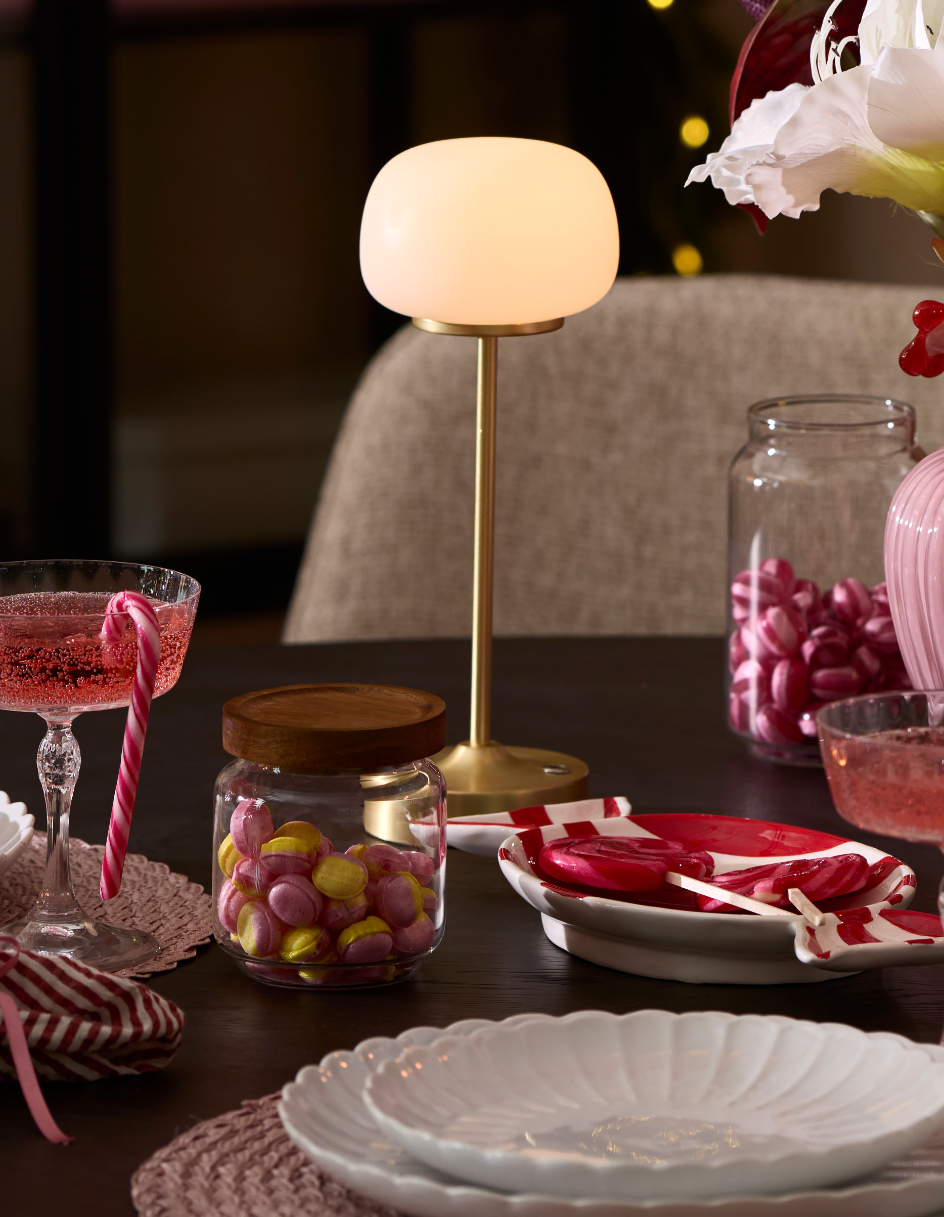 ett dukat bord med en guldig och vit portabel lampa i fokus