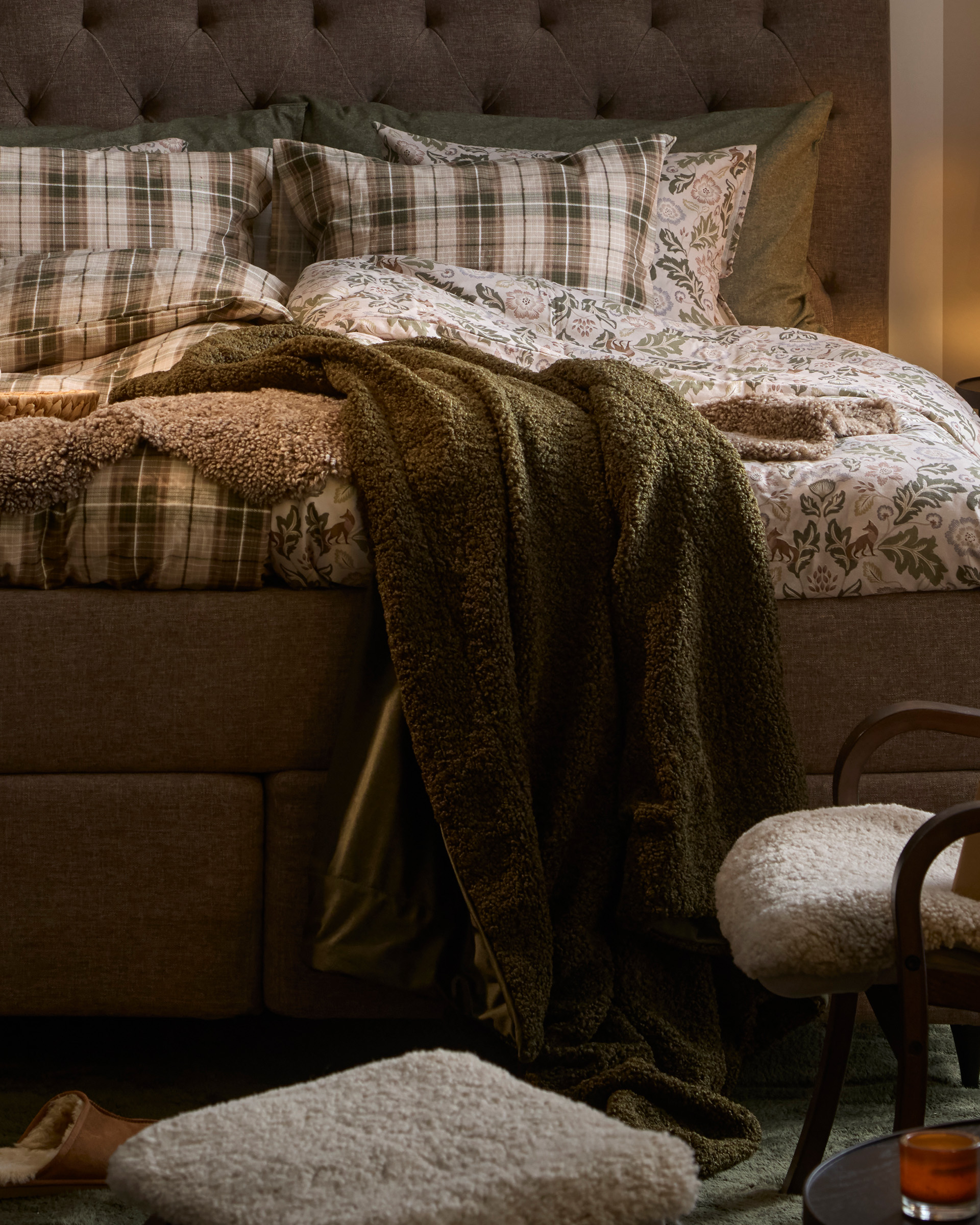 en grön pläd hängandes på en säng