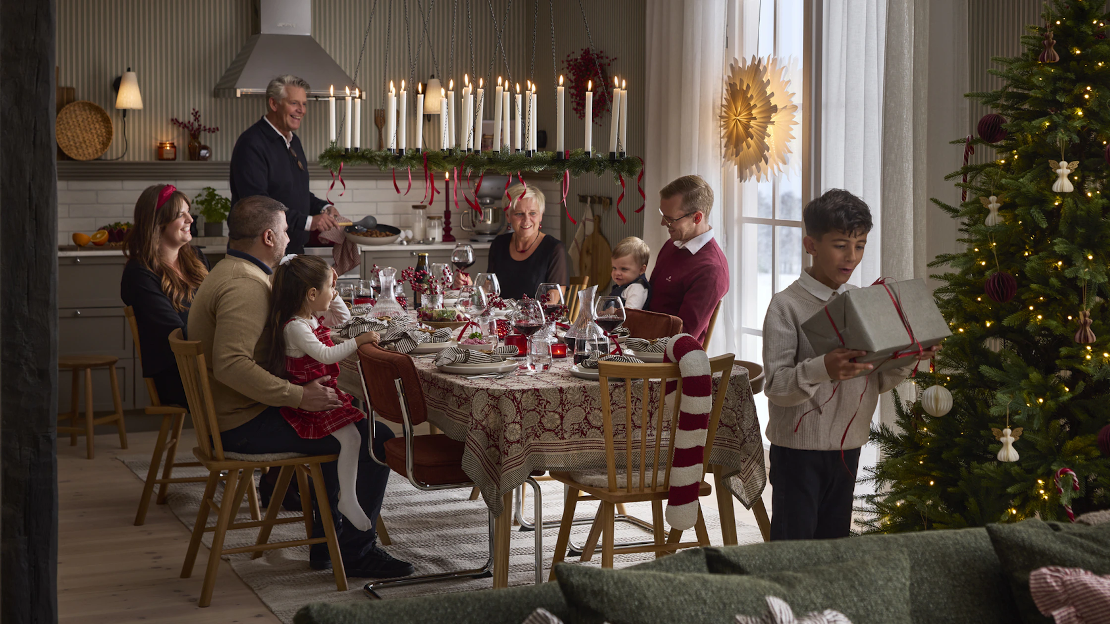 ett hem där man ser ett vardagsrum och ett kök med en familj som firar jul