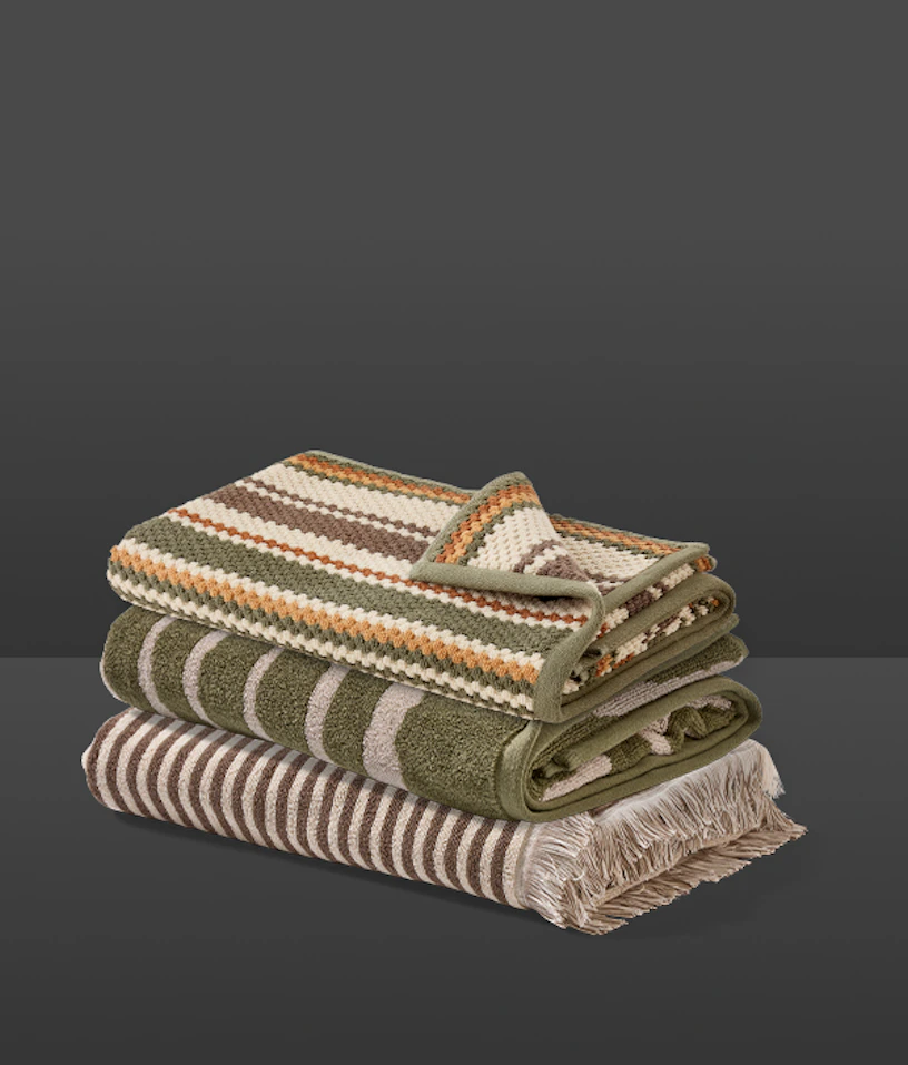 Tre handdukar i olika randiga mönster ligger hopvikta på varandra