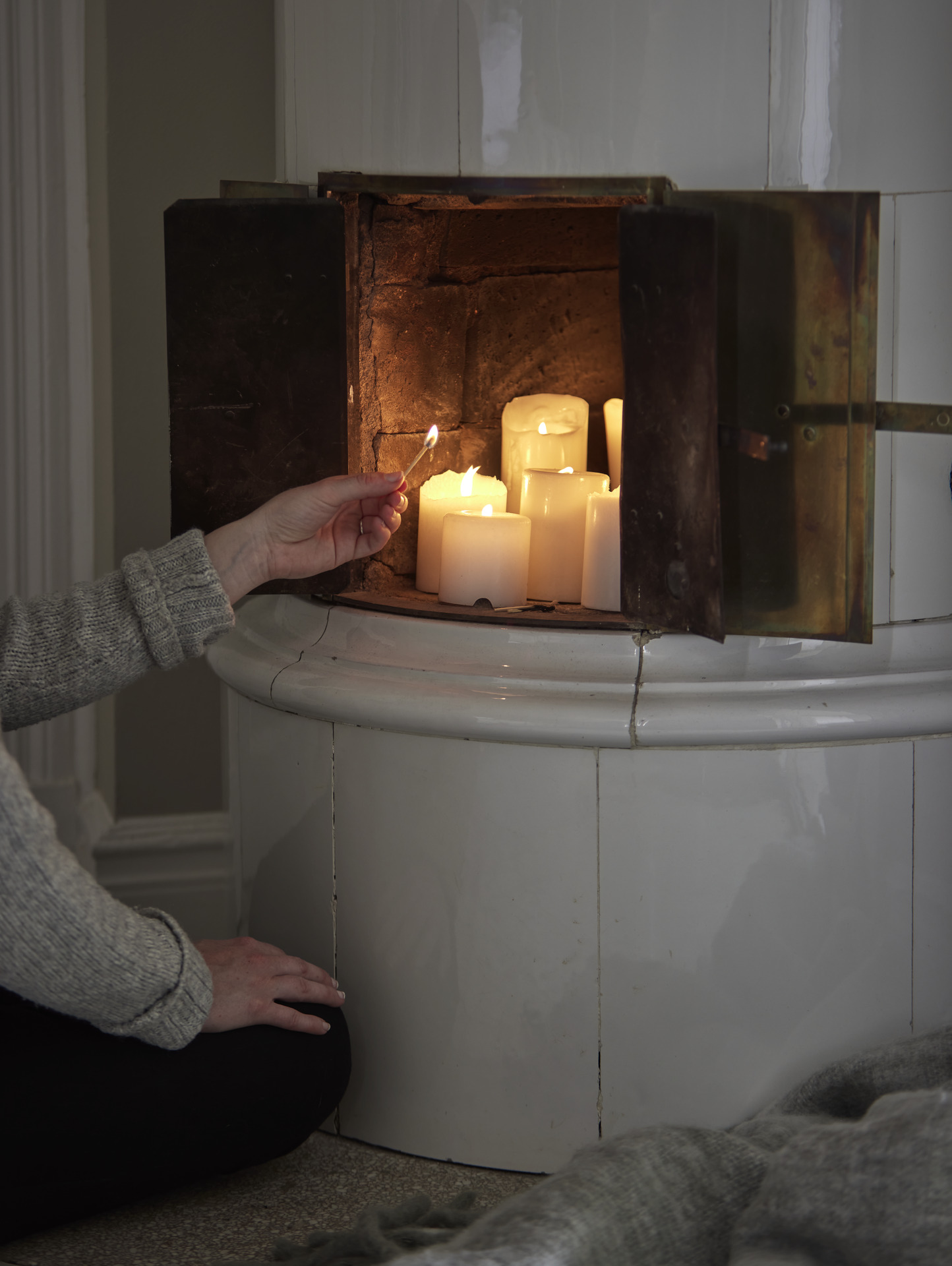 flera tända blockljus ståendes i en kakelugn