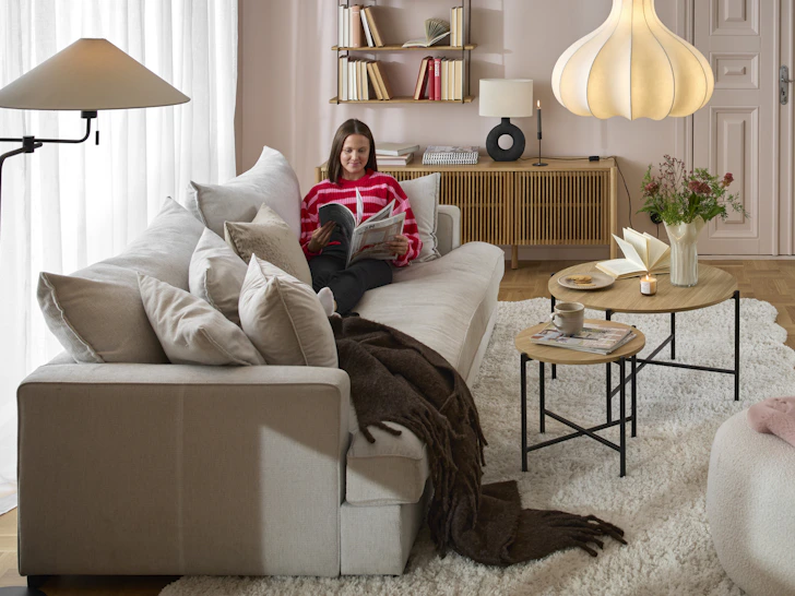 en tjej sittandes i en stor vit soffa i ett vardagsrum
