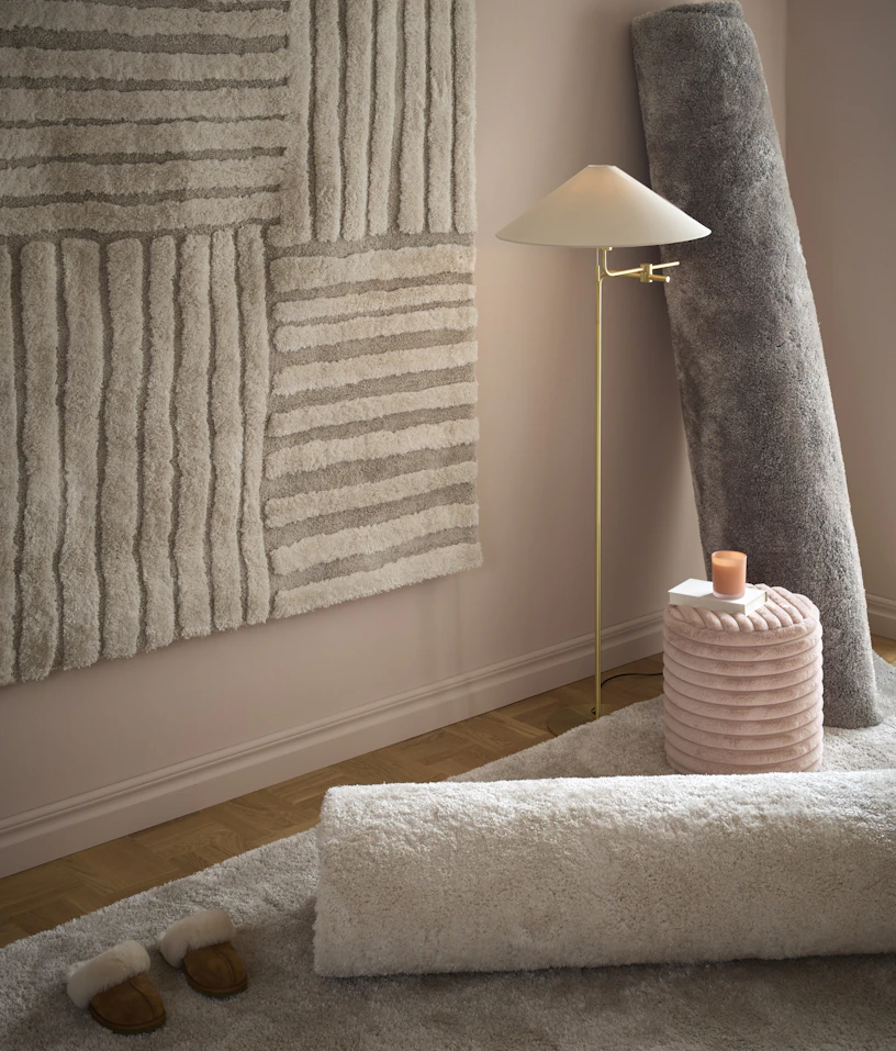 Ett rosa rum är fyllt av fluffiga ryamattor