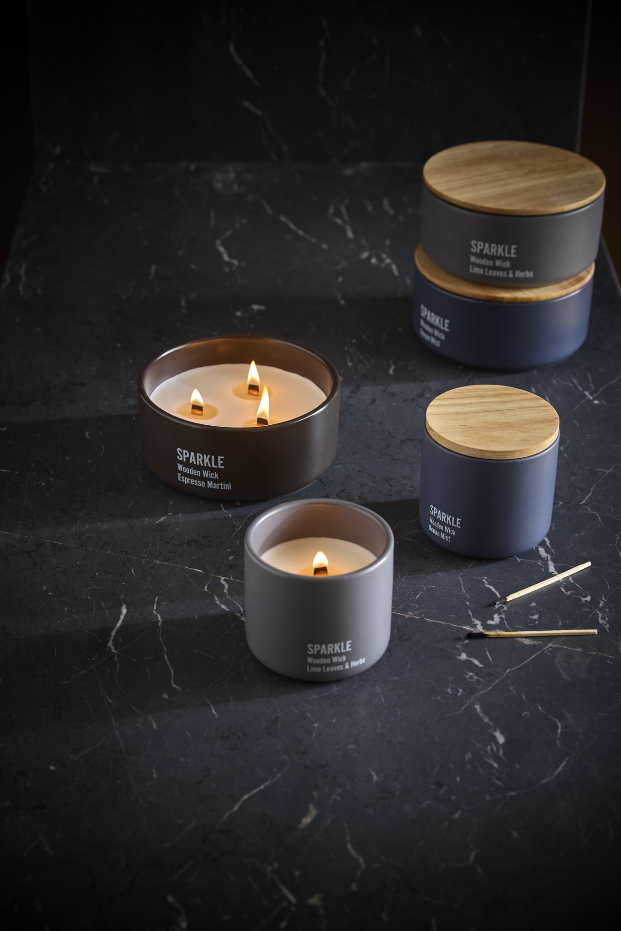 Sprakande doftljus står utställda på en mörk skiva i sten