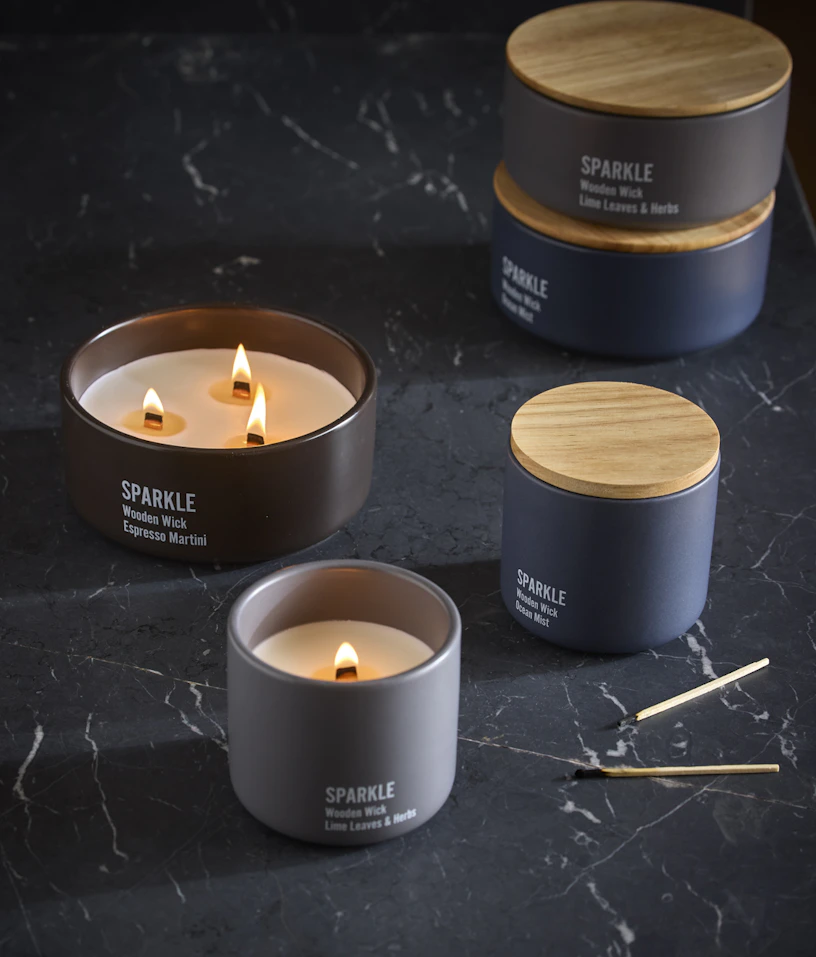 Sprakande doftljus står utställda på en mörk skiva i sten