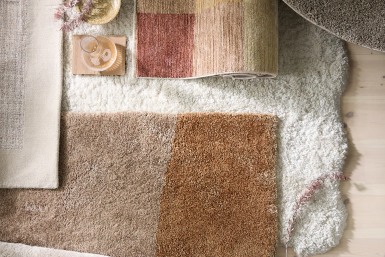 flera mattor i olika färger och mönster liggandes på varandra på golvet