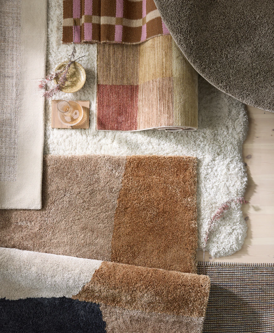 flera mattor i olika färger och mönster liggandes på varandra på golvet