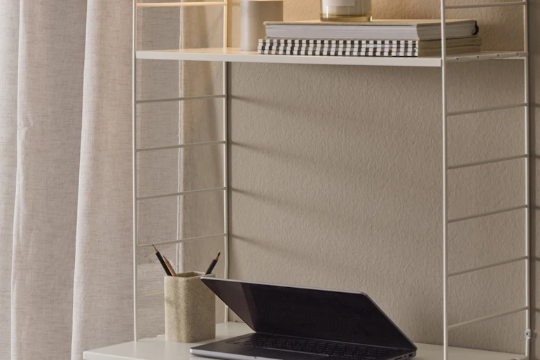 vit hylla med dekoration och en lampa på