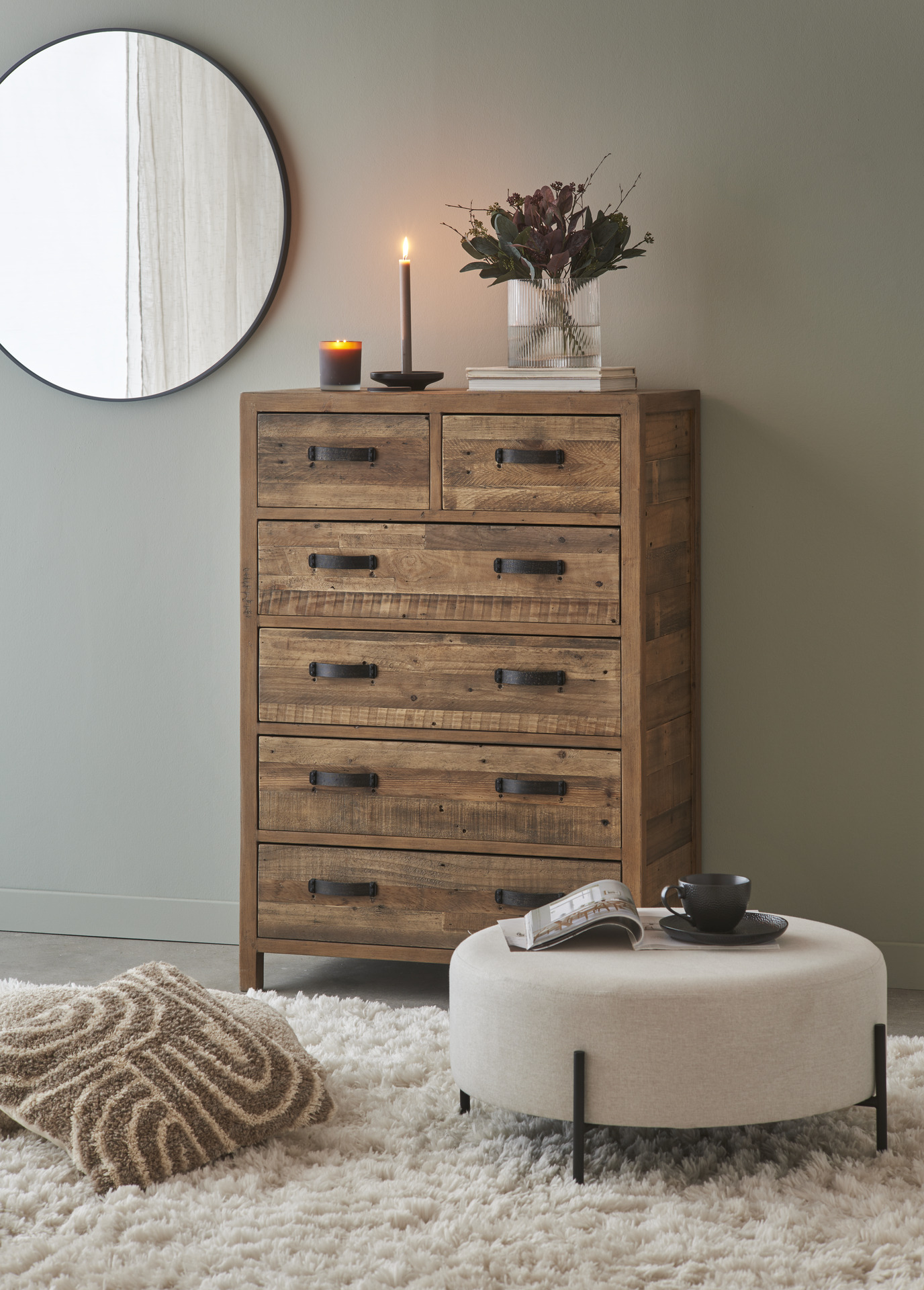 en byrå med svarta handtag står mot en grå vägg