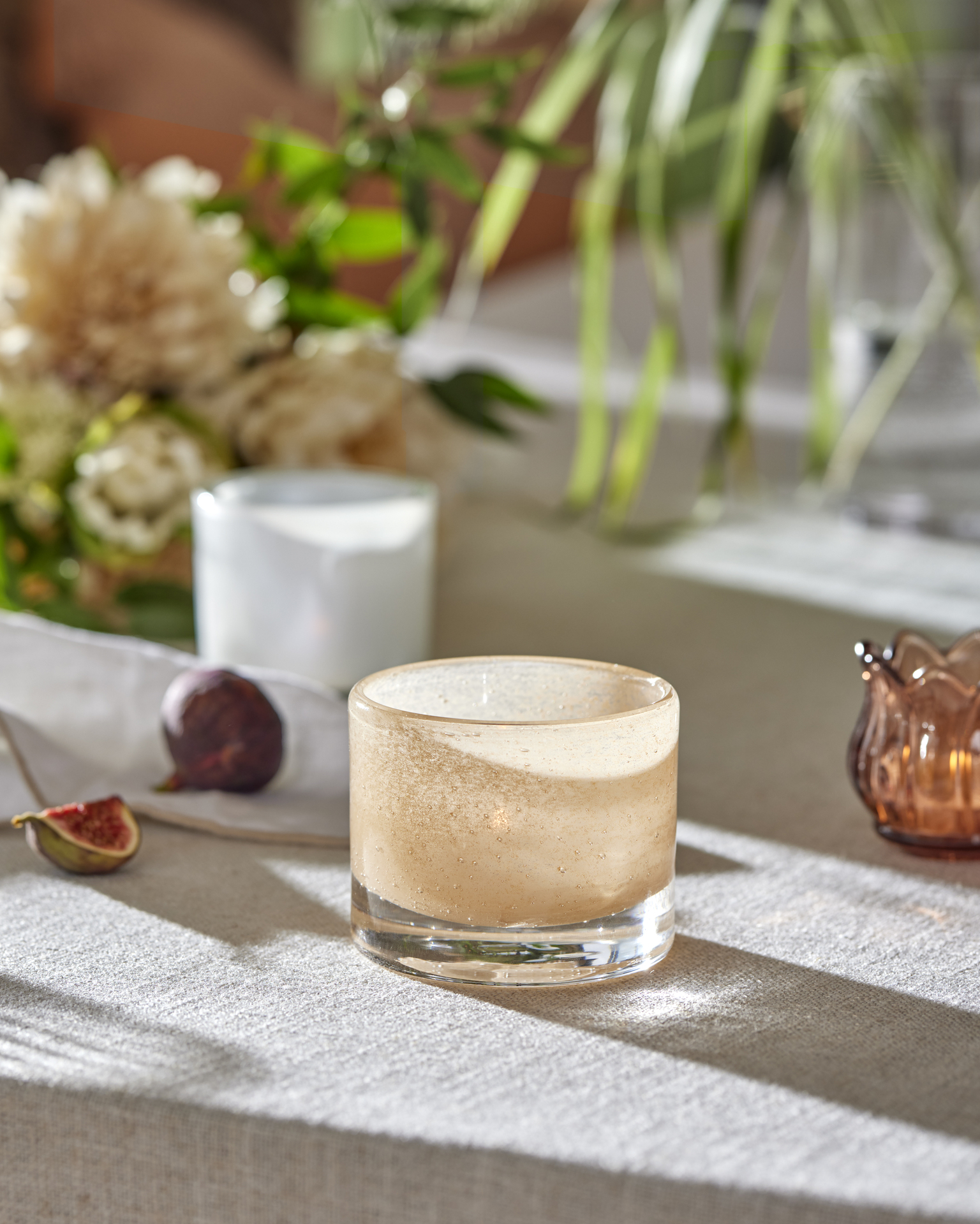 en ljusrosa ljuslykta ståendes på ett bord