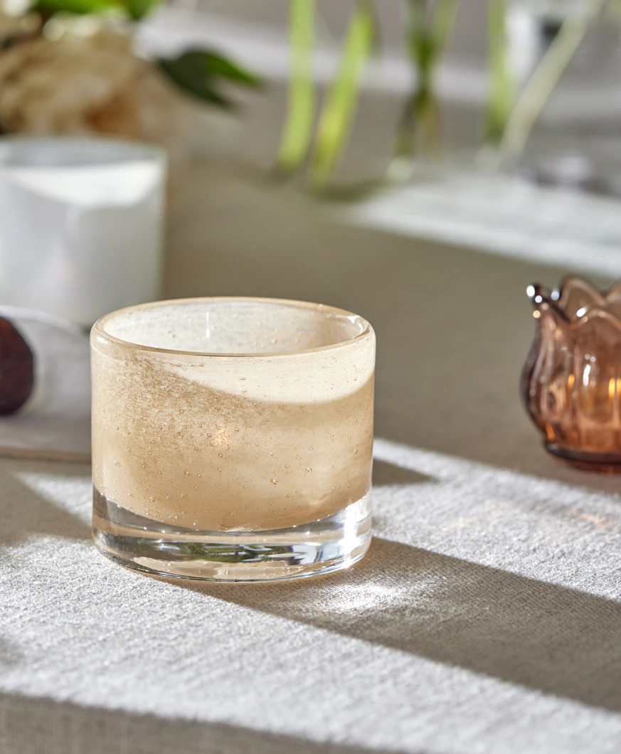 en ljusrosa ljuslykta ståendes på ett bord