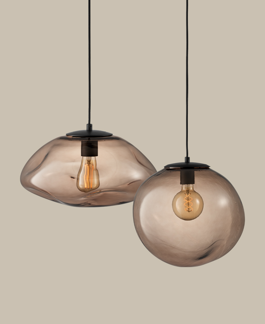 två taklampor i rökigt glas är frilagda mot en beige nakgrund