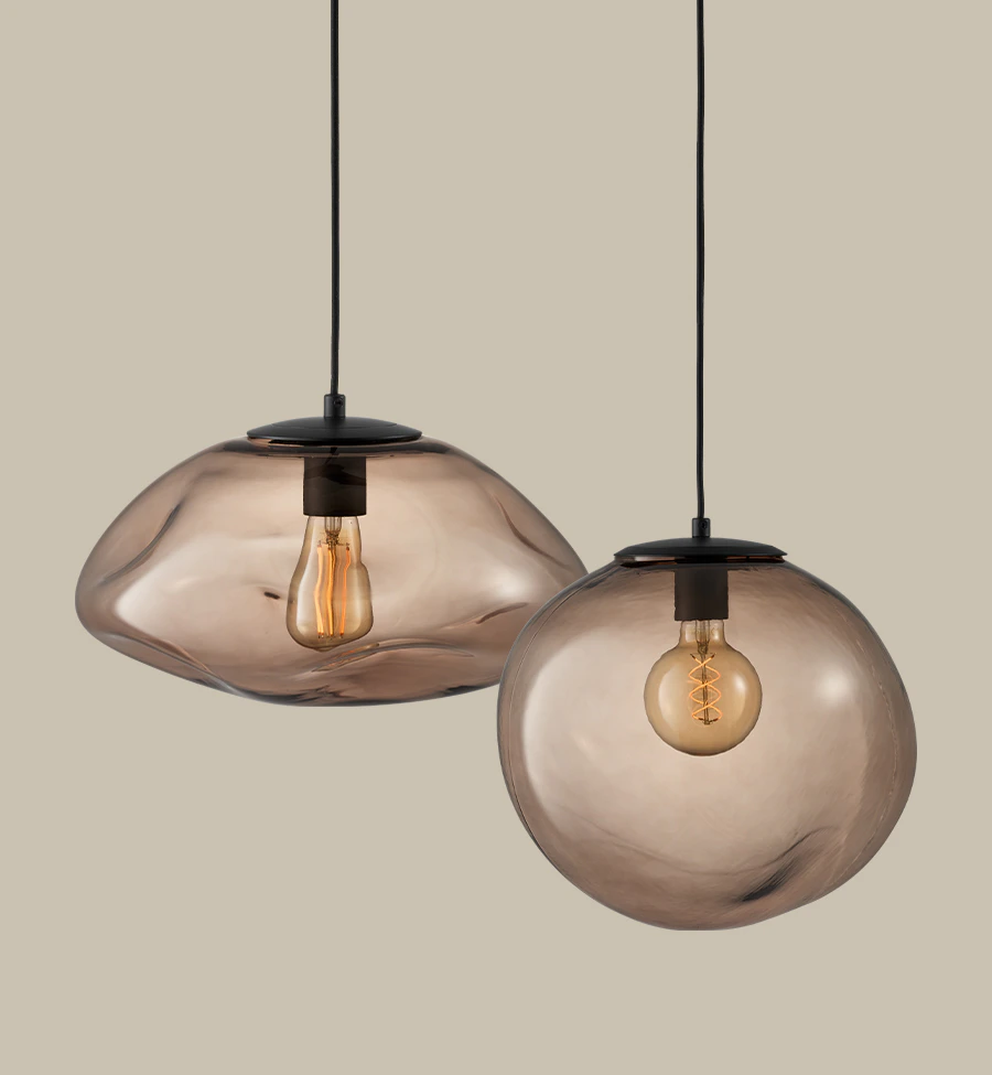 två taklampor i rökigt glas är frilagda mot en beige nakgrund