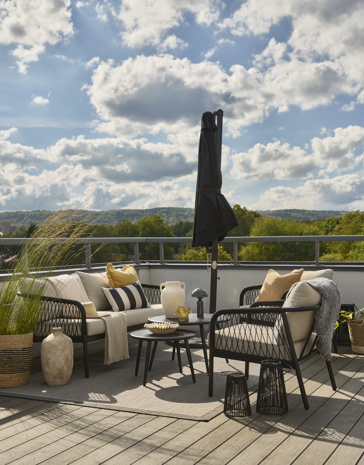 På en uteplats står en utegrupp med soffa, bord och två fåtöljer