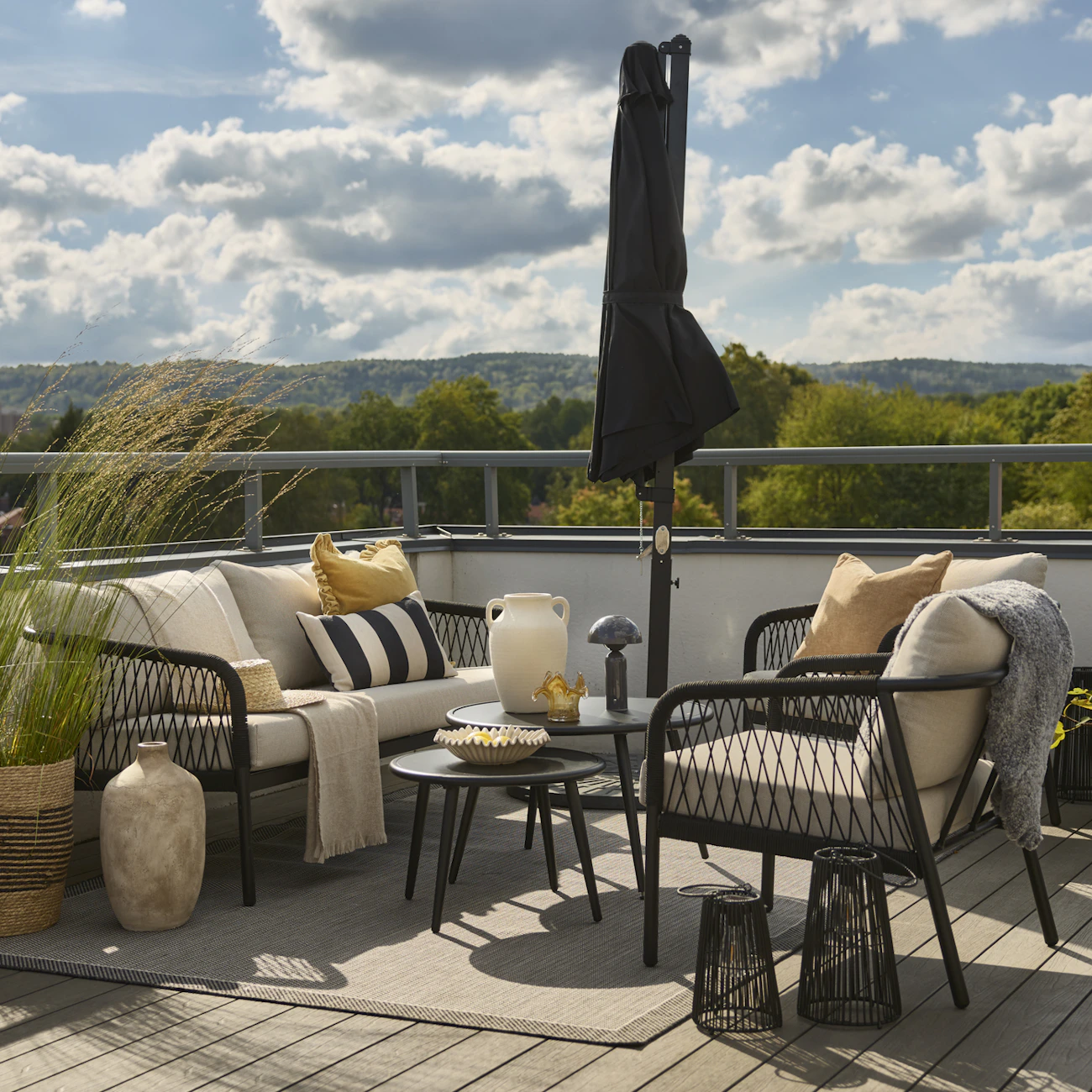 På en uteplats står en utegrupp med soffa, bord och två fåtöljer