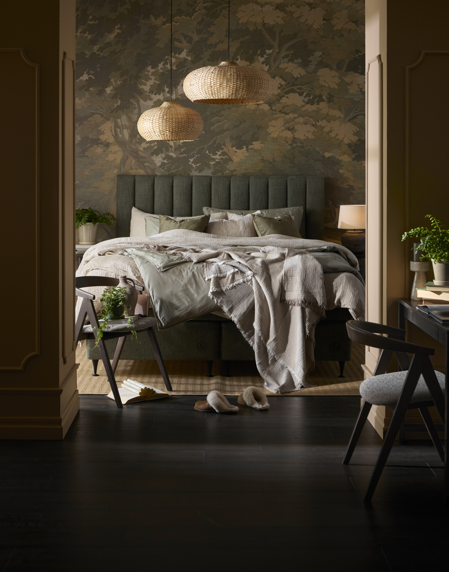 en grön kontinentalsäng står bäddad i ett mörkt sovrum