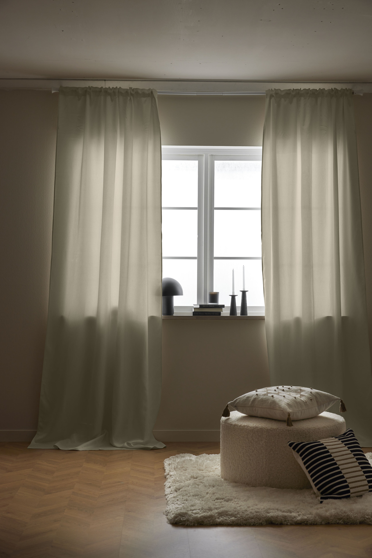 vita gardiner hänger framför ett ljus fönster 