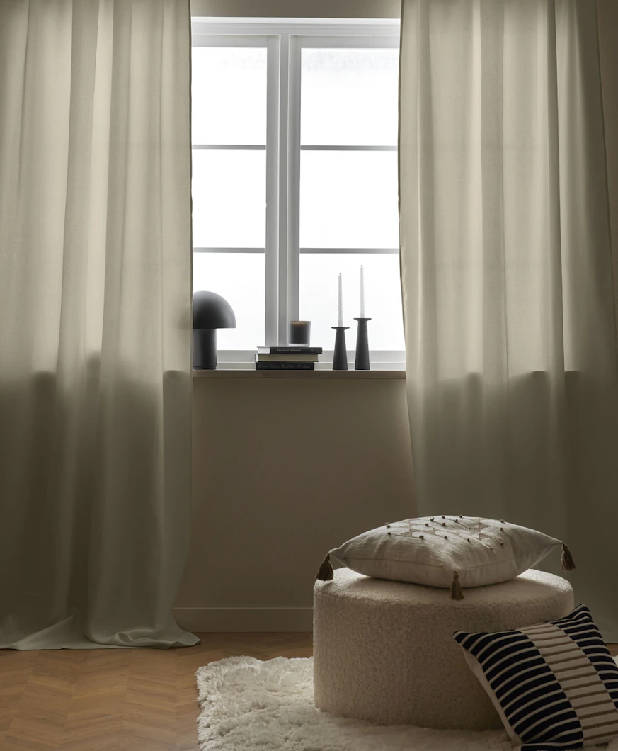 vita gardiner hänger framför ett ljus fönster