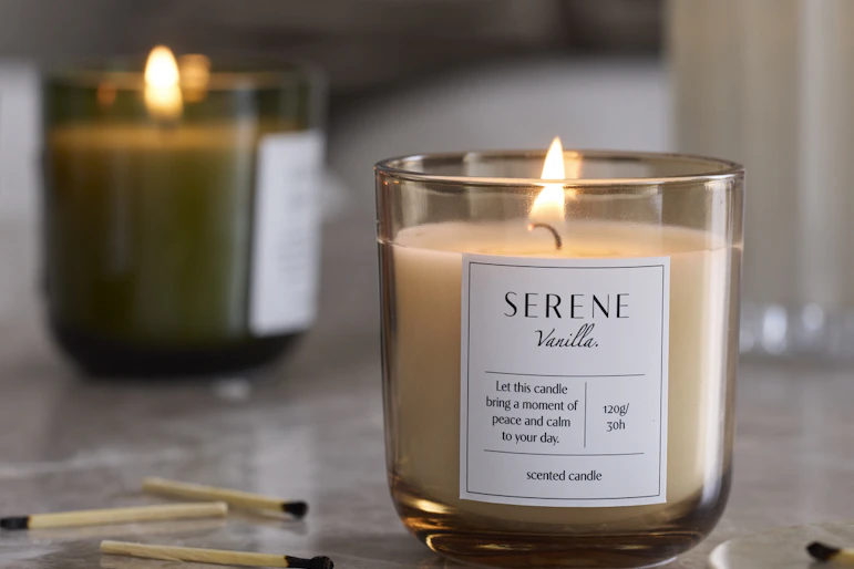 tre doftljus i olika färger står på en stenskiva