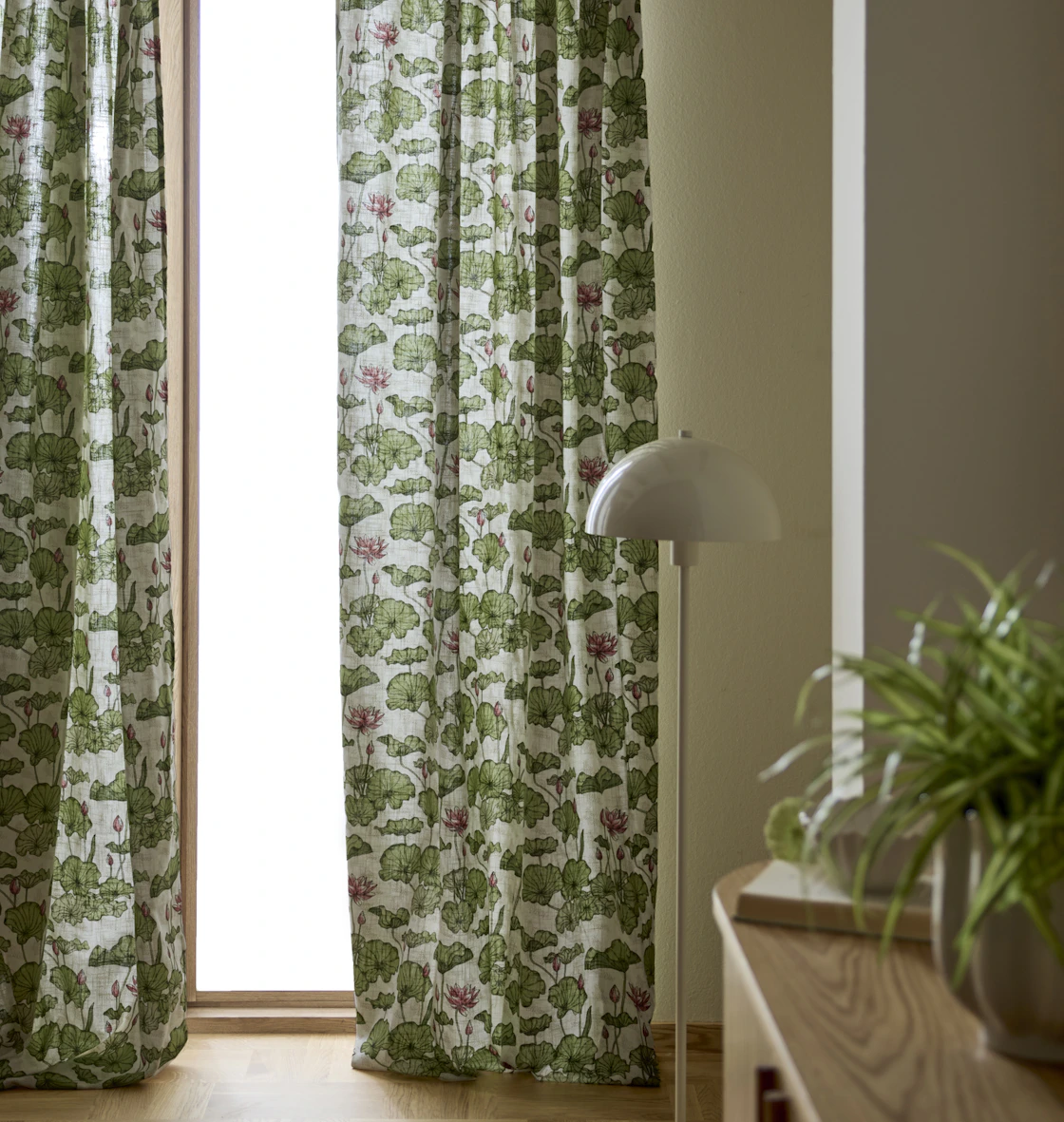 en golvlampa står bredvid ett fönster med mönstrade gardiner