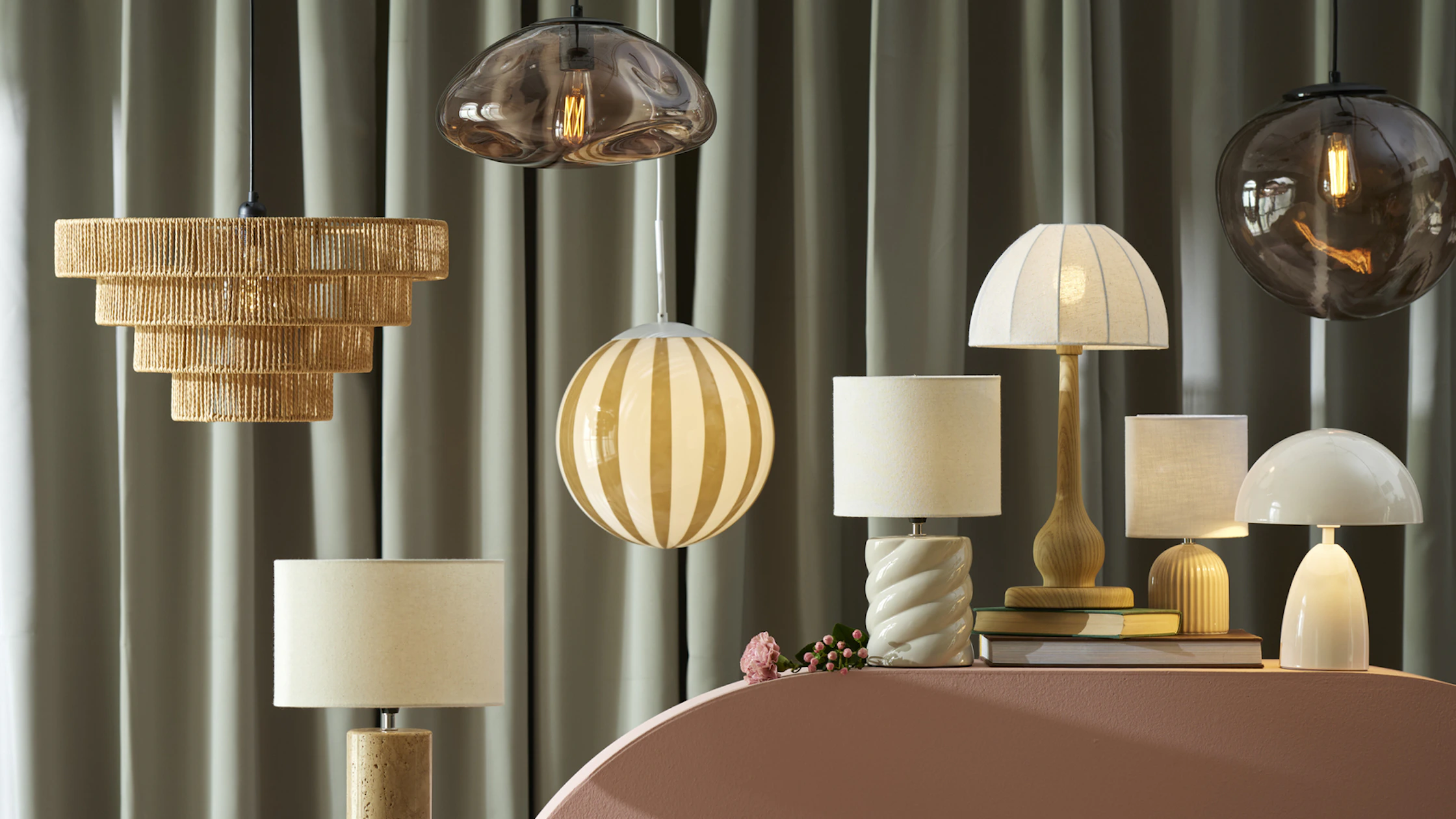 flera lampor ståendes på en rosa bord framför en grön bakgrund