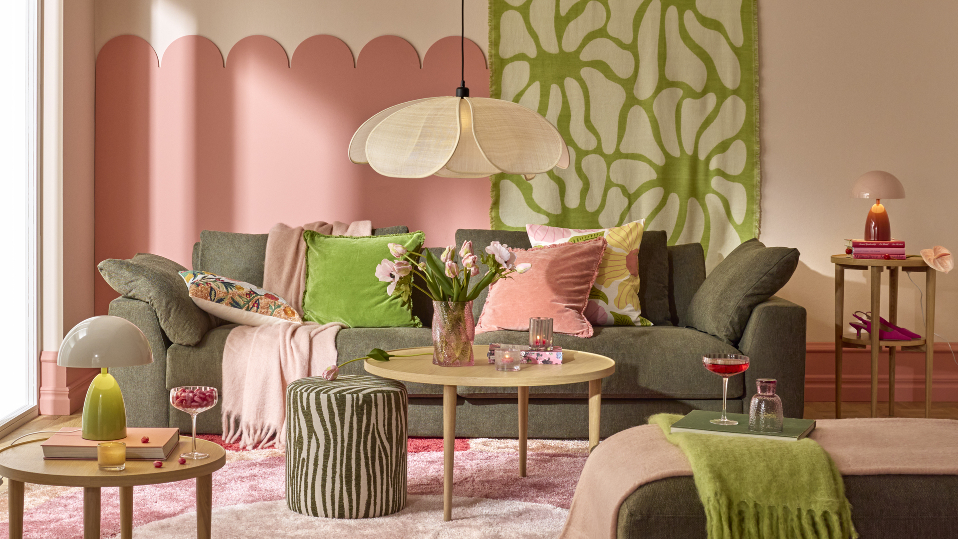 I ett färgglatt vardagsrum står en mörk soffa bakom ett ljust soffbord i trä