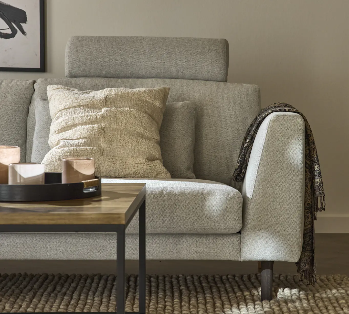 I ett vardagsrum står en ljusgrå, modern Willow soffa med fast klädsel