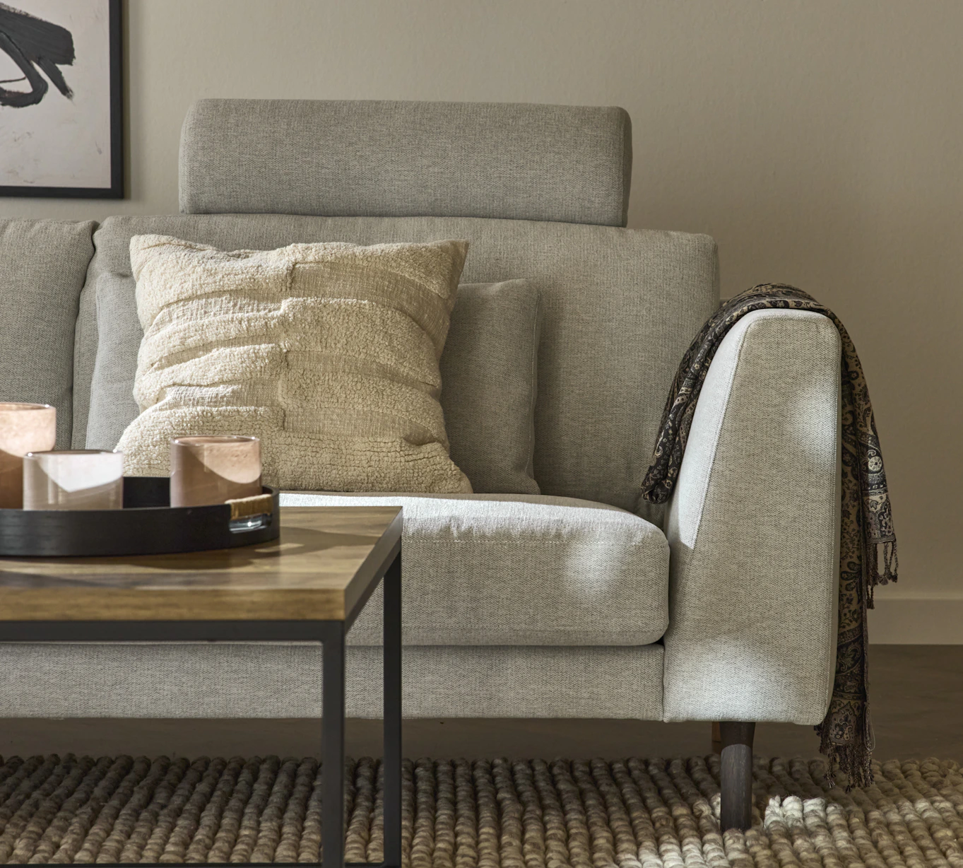 I ett vardagsrum står en ljusgrå, modern Willow soffa med fast klädsel