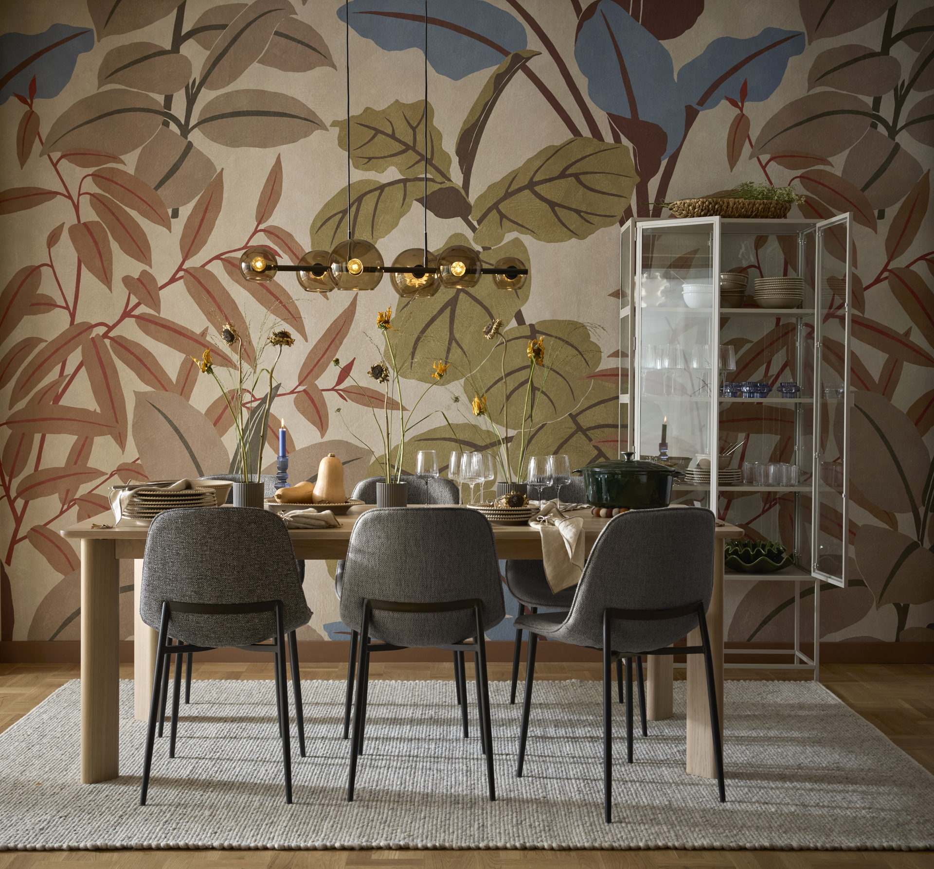 En matgrupp med sex gråa stolar står i ett rum med stormönstrad tapet.