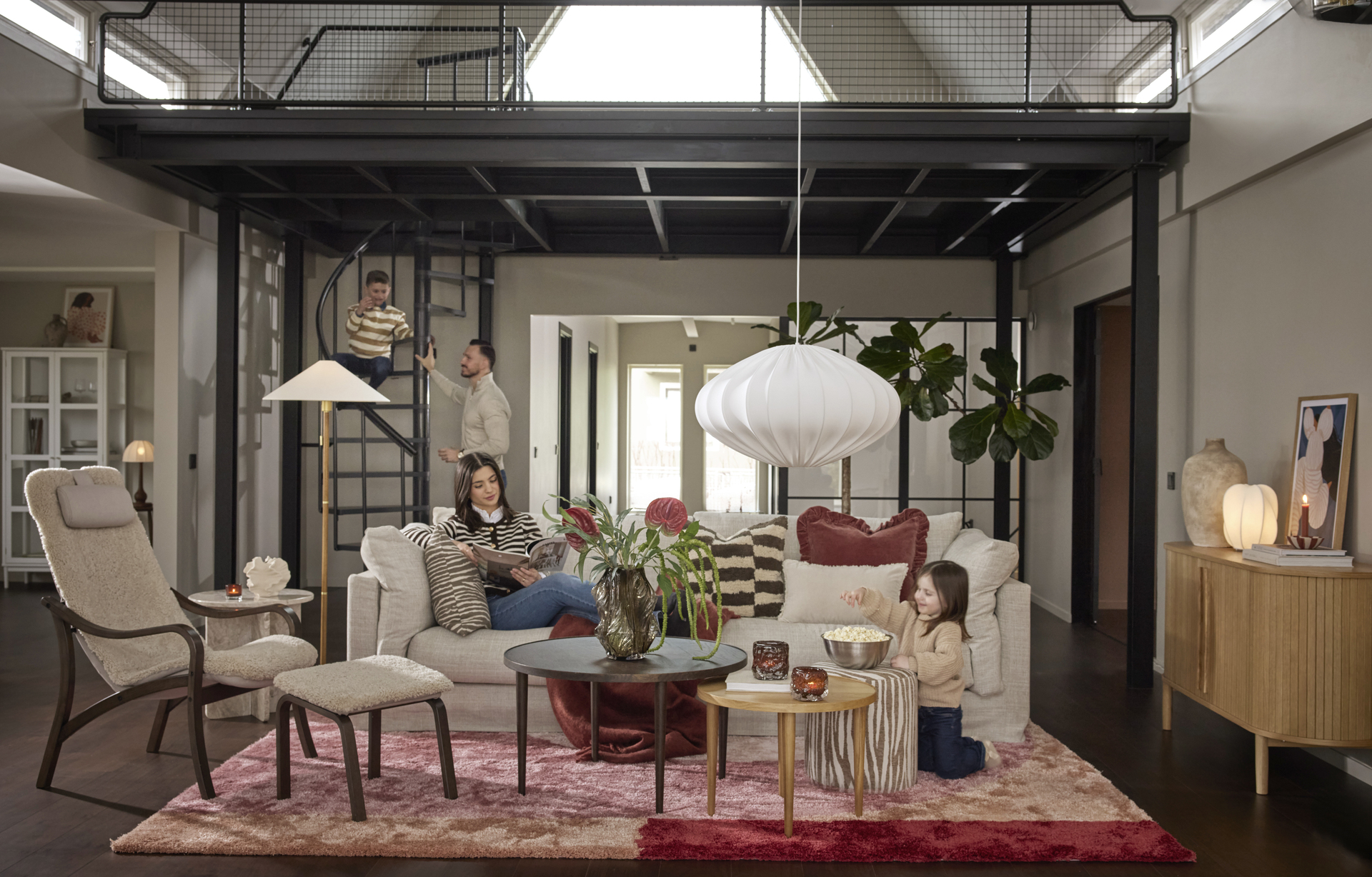 I en vit soffa i mitten av ett vardagsrum sitter en kvinna