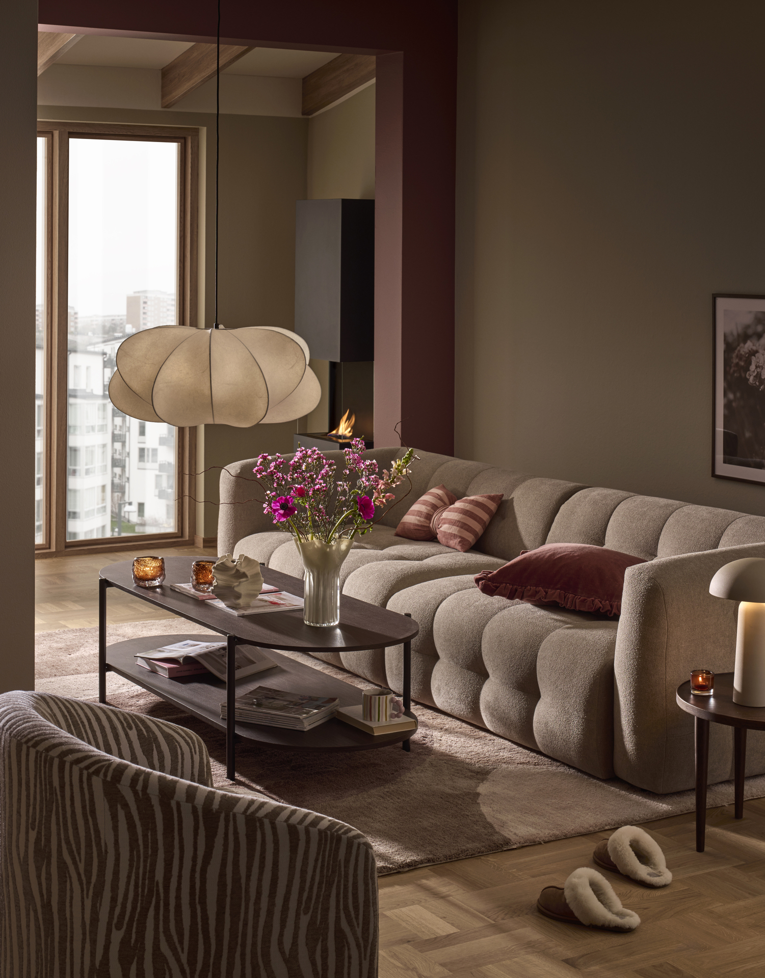 I ett beigemålat vardagsrum med rosa detaljer står den trendsäkra soffan Bella